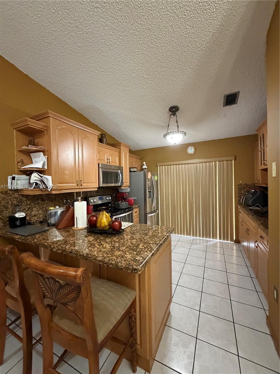 7792 West 29th Way, Unit 202 Hialeah, FL 33018 - Photo 3 of 14 a kitchen with stainless steel appliances granite countertop a sink and a refrigerator