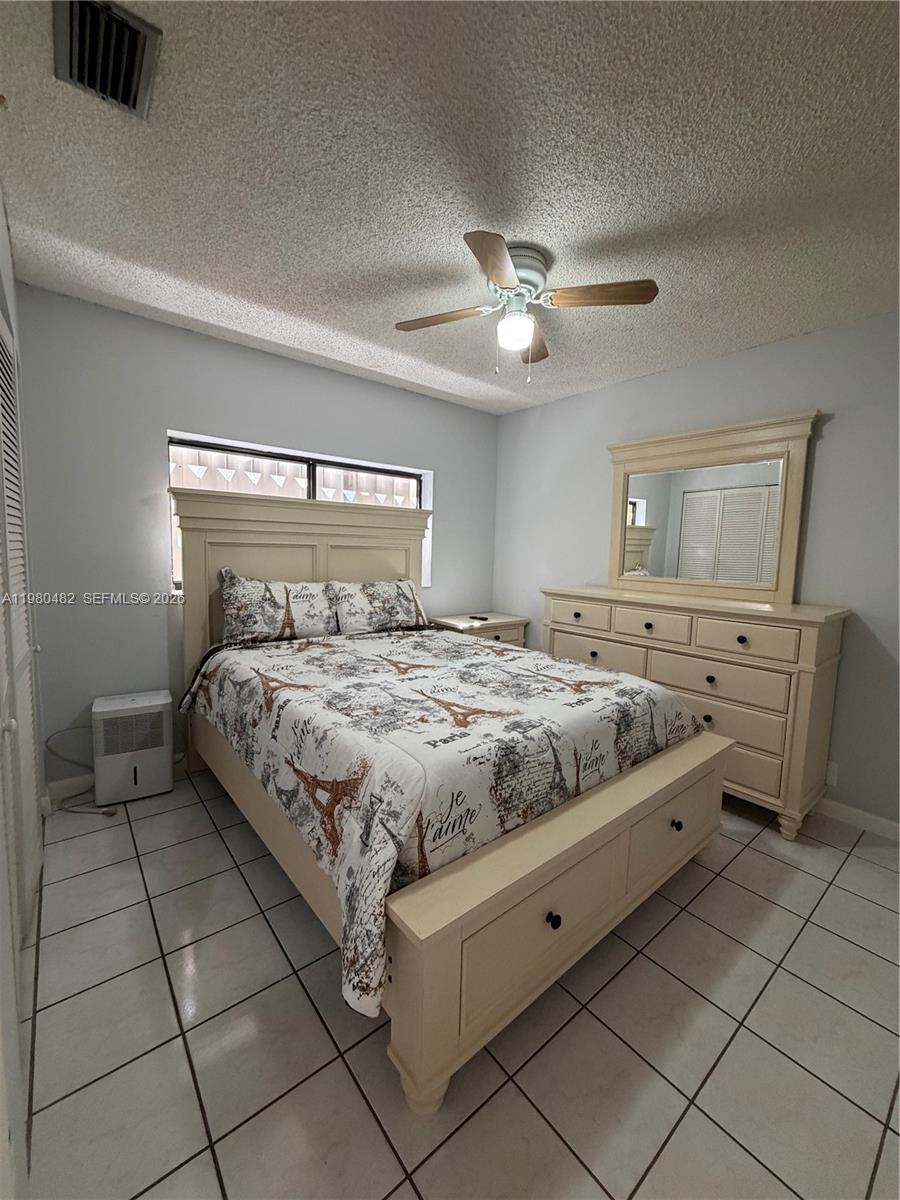 7792 West 29th Way, Unit 202 Hialeah, FL 33018 - Photo 8 of 14 a bedroom with a large bed and a chandelier