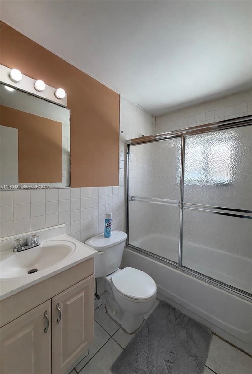 7792 West 29th Way, Unit 202 Hialeah, FL 33018 - Photo 9 of 14 a bathroom with a toilet a sink and glass door