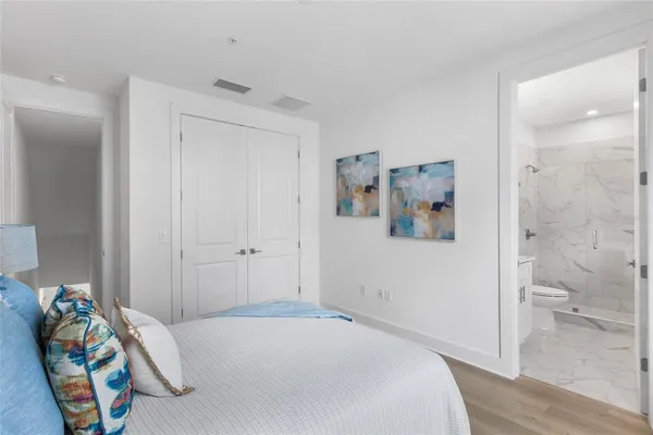 a bedroom with a bed and a painting on the wall