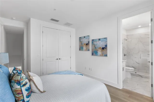 a bedroom with a bed and a painting on the wall