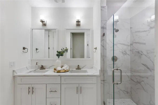 a bathroom with a granite countertop sink a shower and a mirror