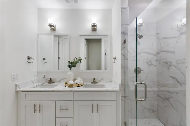 a bathroom with a granite countertop sink a shower and a mirror