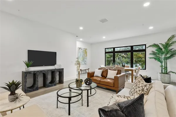 a living room with furniture a flat screen tv and a large window