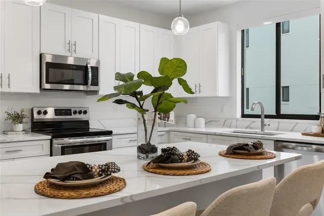 a kitchen with stainless steel appliances granite countertop a sink a stove and cabinets