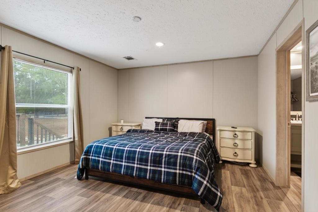 1088 Mulberry Landing Road Hilliard, FL 32046 - Photo 17 of 30 a bedroom with a bed and wooden floor