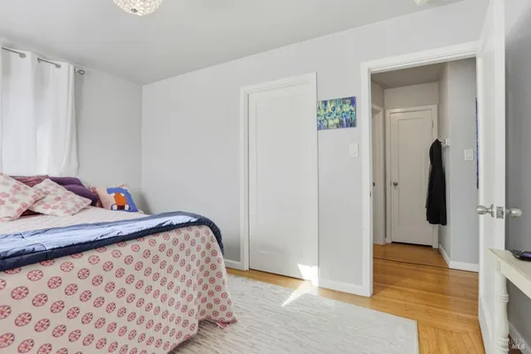 a bedroom with bed and wooden floor
