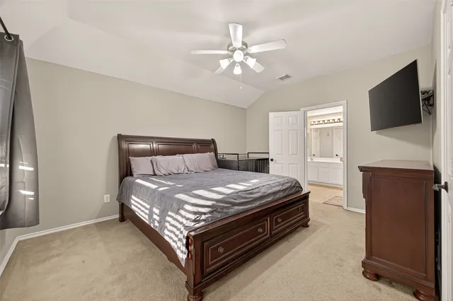 a bedroom with a large bed a flat tv screen and a walk in closet