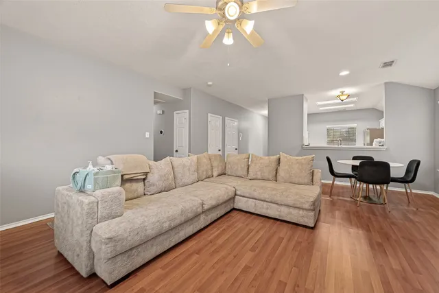 a living room with furniture and a wooden floor