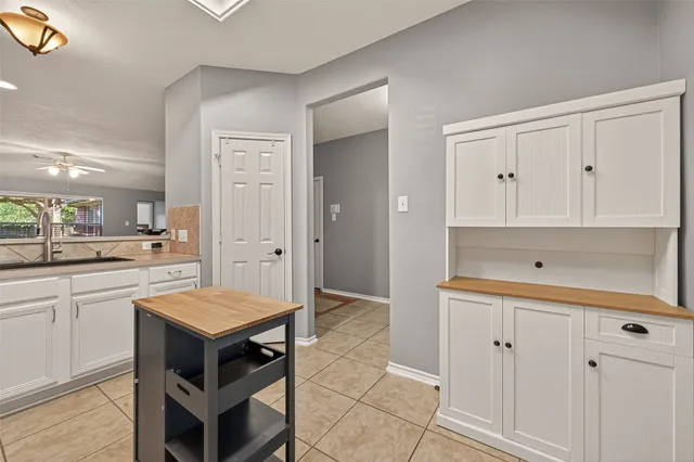 a kitchen with white cabinets and wooden floors