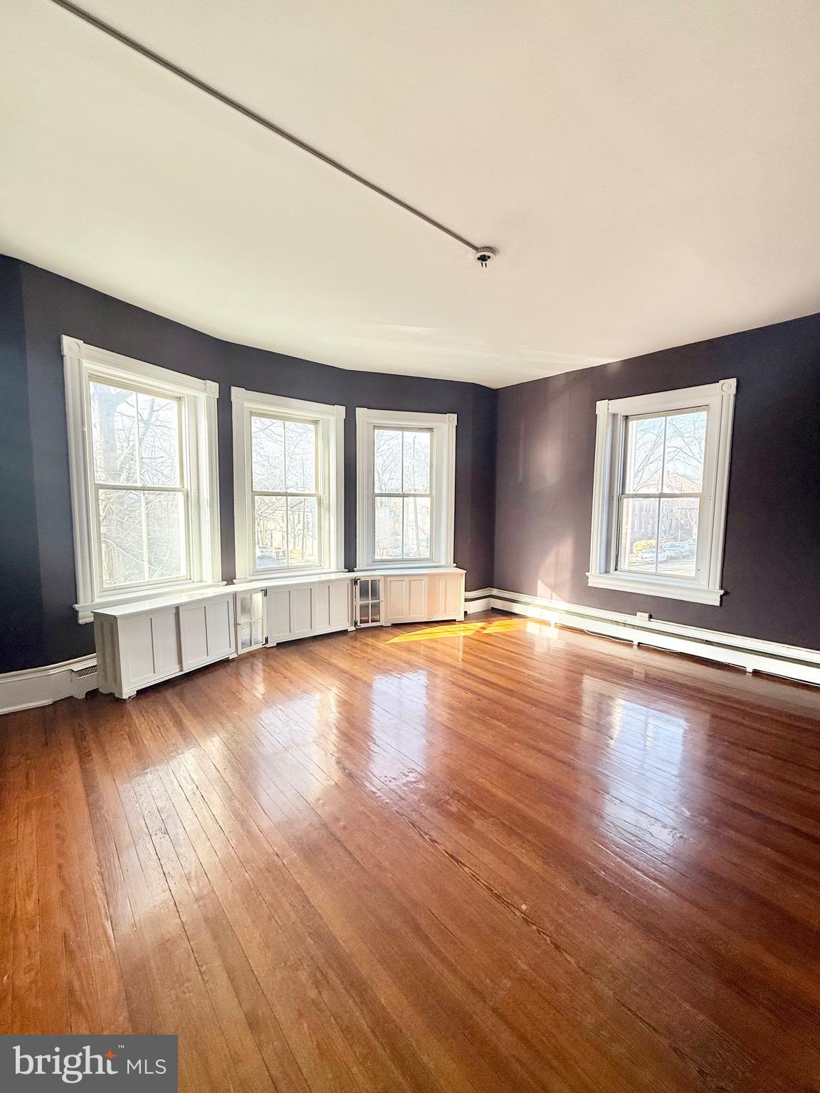 718 Oronoco Street, Unit 2 Alexandria, VA 22314 - Photo 2 of 27 an empty room with wooden floor and windows