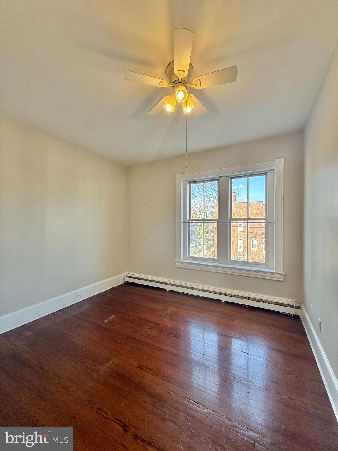 718 Oronoco Street, Unit 2 Alexandria, VA 22314 - Photo 6 of 27 a view of an empty room with wooden floor and a window