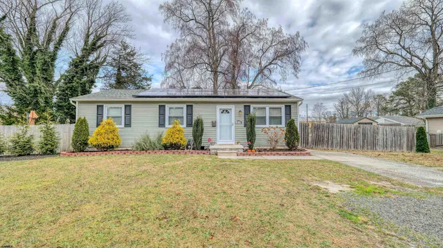 front view of a house with a big yard and potted plants