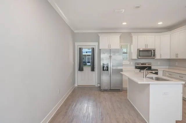 a kitchen with stainless steel appliances granite countertop a refrigerator a sink a stove a microwave and cabinets