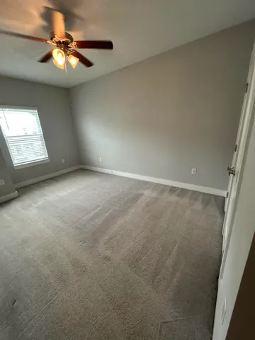a view of an empty room and a chandelier fan