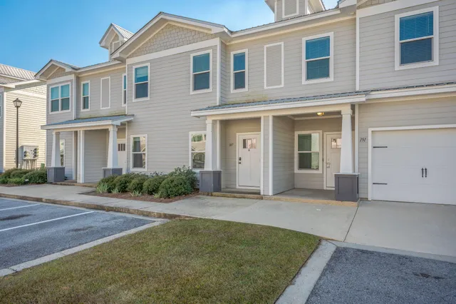 a front view of a house with yard and parking