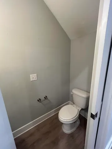 a white toilet sitting next to a shower