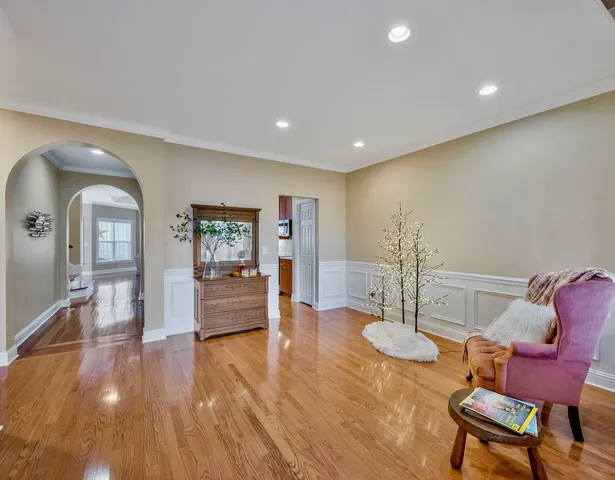 a view of a livingroom with furniture a kitchen view and wooden floor