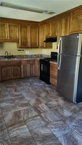 a kitchen with stainless steel appliances granite countertop a refrigerator a stove a sink and a microwave