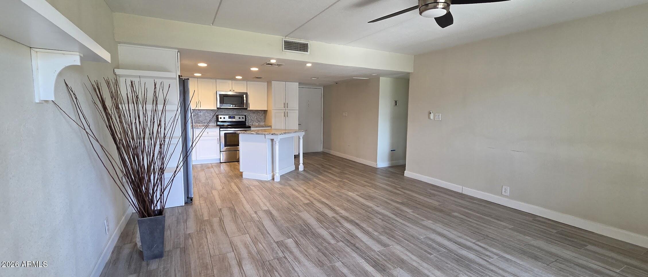 7910 East Camelback Road, Unit 104 Scottsdale, AZ 85251 - Photo 28 of 38 a view of a kitchen with a sink refrigerator wooden floor and a window