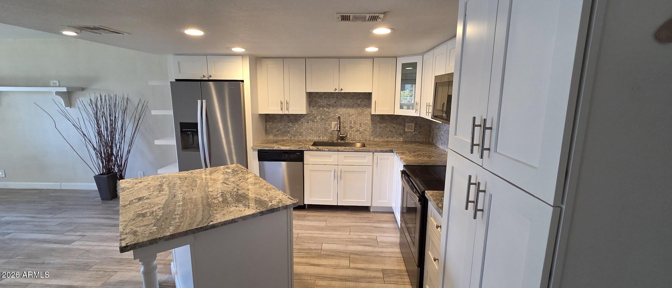 7910 East Camelback Road, Unit 104 Scottsdale, AZ 85251 - Photo 29 of 38 a kitchen with stainless steel appliances granite countertop a refrigerator and a stove