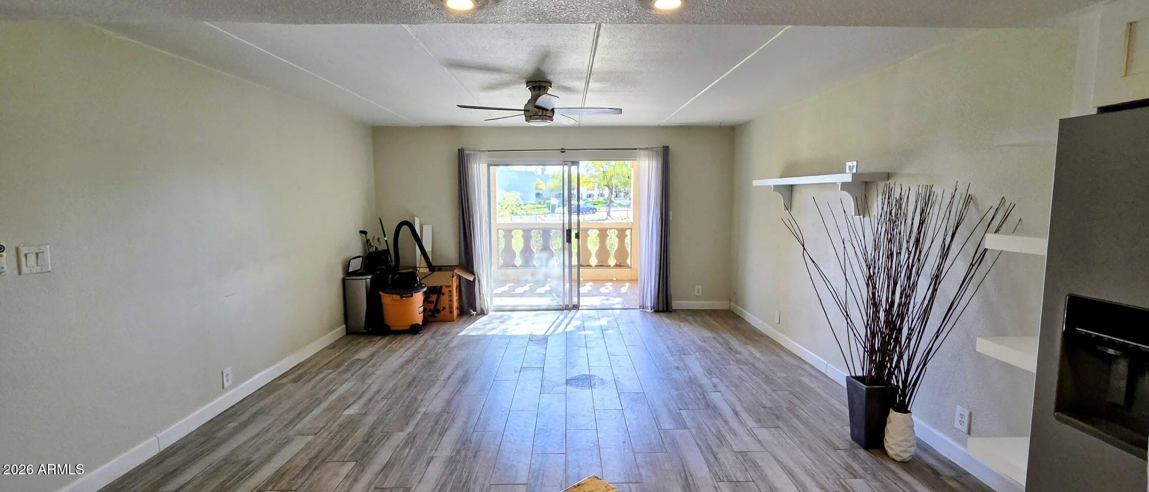 7910 East Camelback Road, Unit 104 Scottsdale, AZ 85251 - Photo 31 of 38 a view of a room with wooden floor and a ceiling fan
