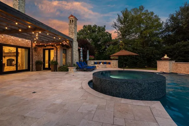 a view of patio with a table and chairs under an umbrella with a fire pit