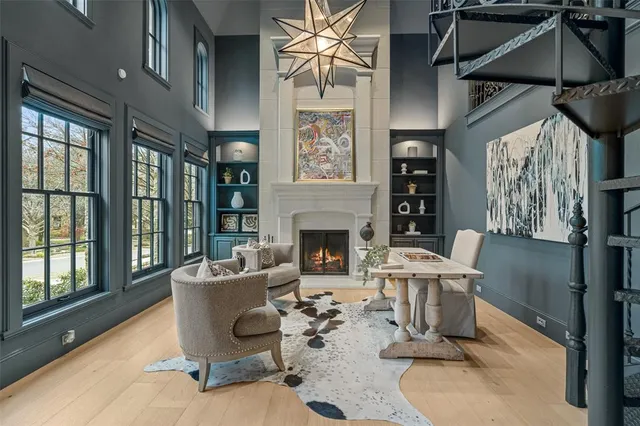 a living room with furniture a fireplace and a floor to ceiling window