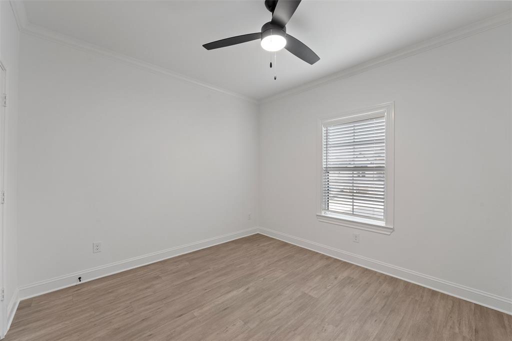 2113 Holborn Street Lorena, TX 76655 - Photo 19 of 31 an empty room with wooden floor chandelier fan and windows