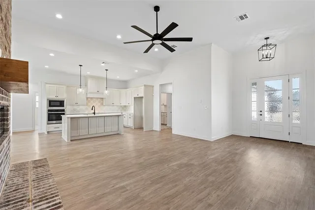 a view of kitchen with stainless steel appliances refrigerator oven and cabinets