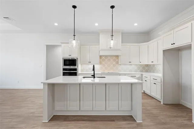a kitchen with kitchen island white cabinets and refrigerator