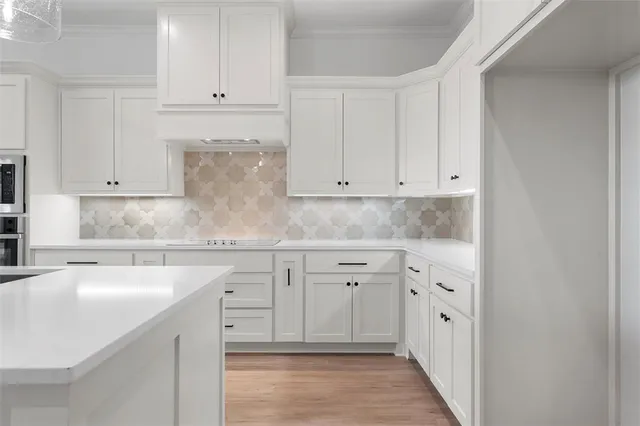 a kitchen with granite countertop white cabinets and sink