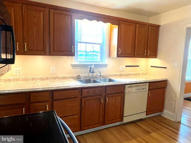 a kitchen with granite countertop a sink stove and cabinets