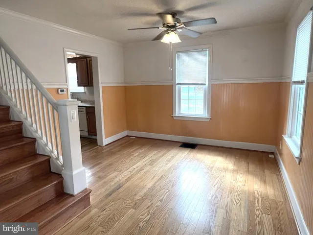 an empty room with wooden floor and entrance