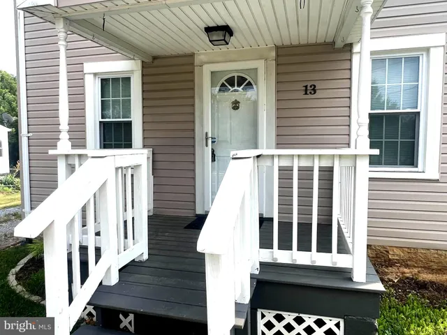 a view of a house with wooden fence and two windows