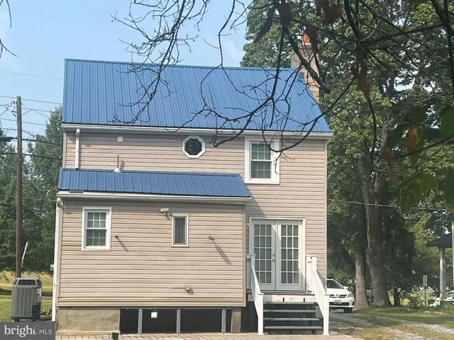 a view of a house with a tree and wooden fence