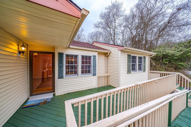 a view of a house with a small yard and wooden floor and fence