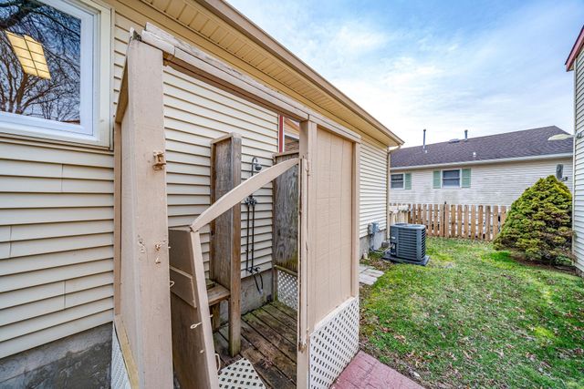 a view of a house with a yard and large tree