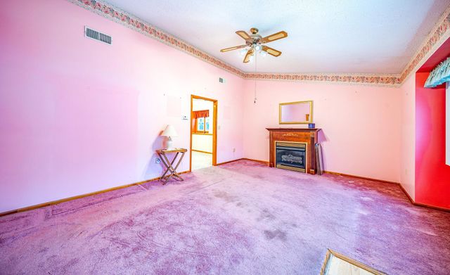 a view of empty room with a fireplace and a workspace