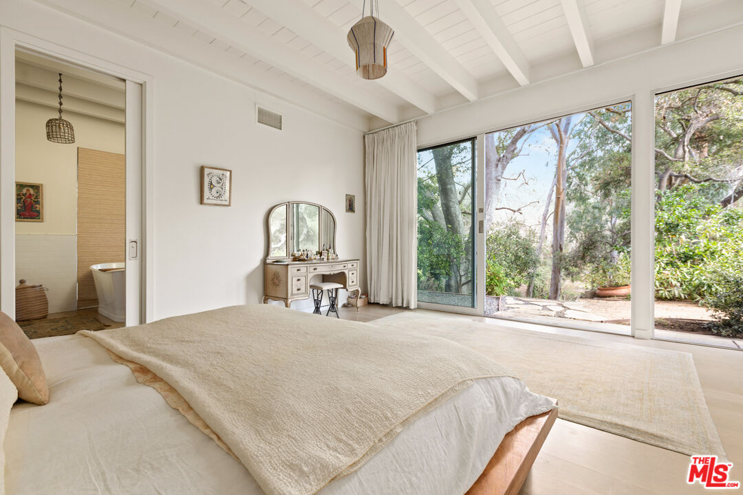 830 Brooktree Road Pacific Palisades, CA 90272 - Photo 28 of 37 a bedroom with a bed large window and couch