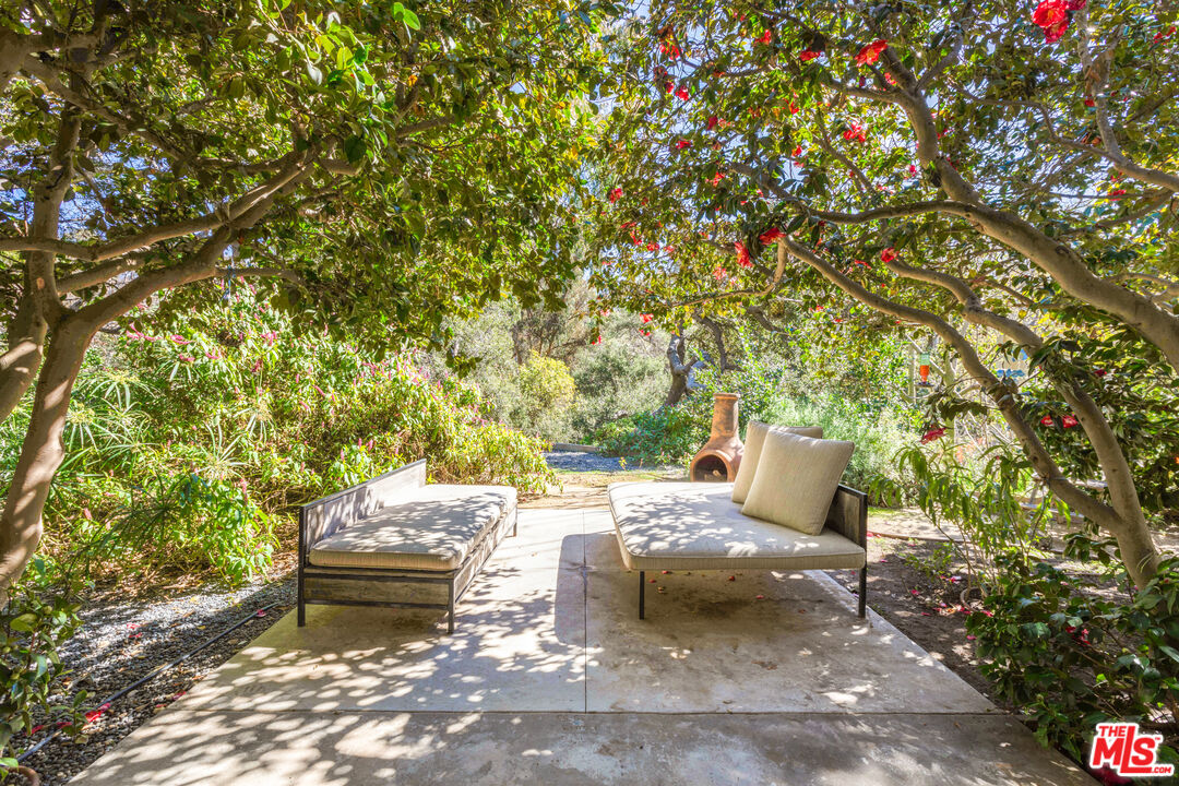 830 Brooktree Road Pacific Palisades, CA 90272 - Photo 32 of 37 a backyard of a house with table and chairs