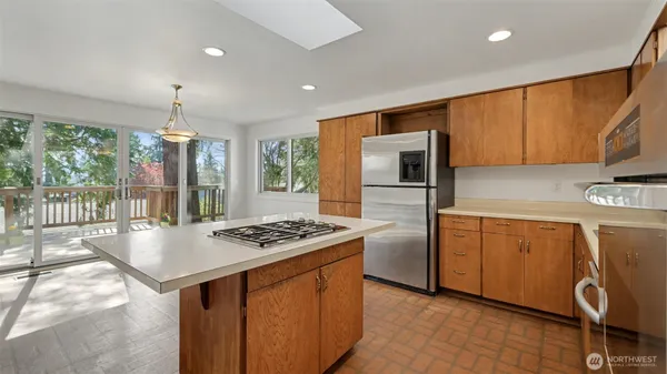 a kitchen with granite countertop a stove a sink dishwasher and a refrigerator with wooden floor