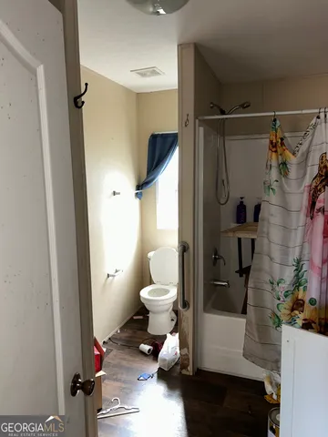 a bathroom with a toilet and a shower
