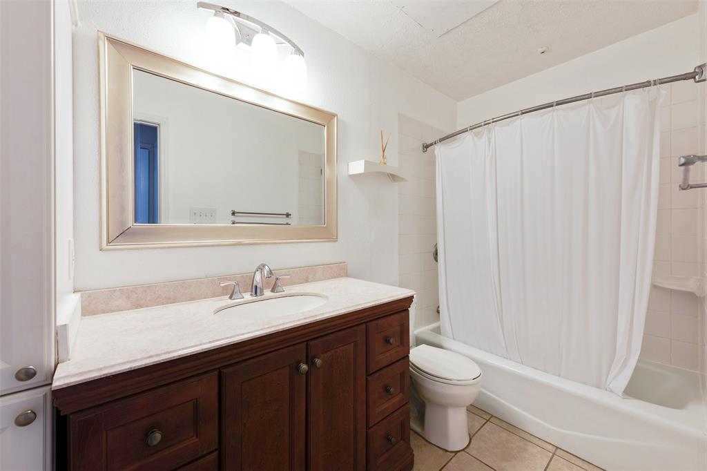 9100 Mountain Ridge Drive, Unit 105 Austin, TX 78759 - Photo 11 of 17 a bathroom with a sink a toilet and a mirror