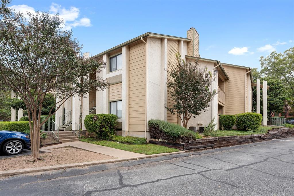 9100 Mountain Ridge Drive, Unit 105 Austin, TX 78759 - Photo 16 of 17 a front view of a house with a yard and garage