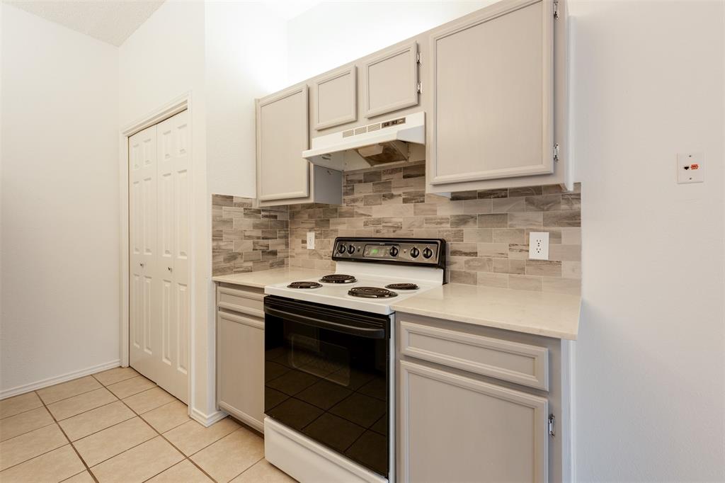 9100 Mountain Ridge Drive, Unit 105 Austin, TX 78759 - Photo 7 of 17 a kitchen with stainless steel appliances white cabinets and a stove top oven