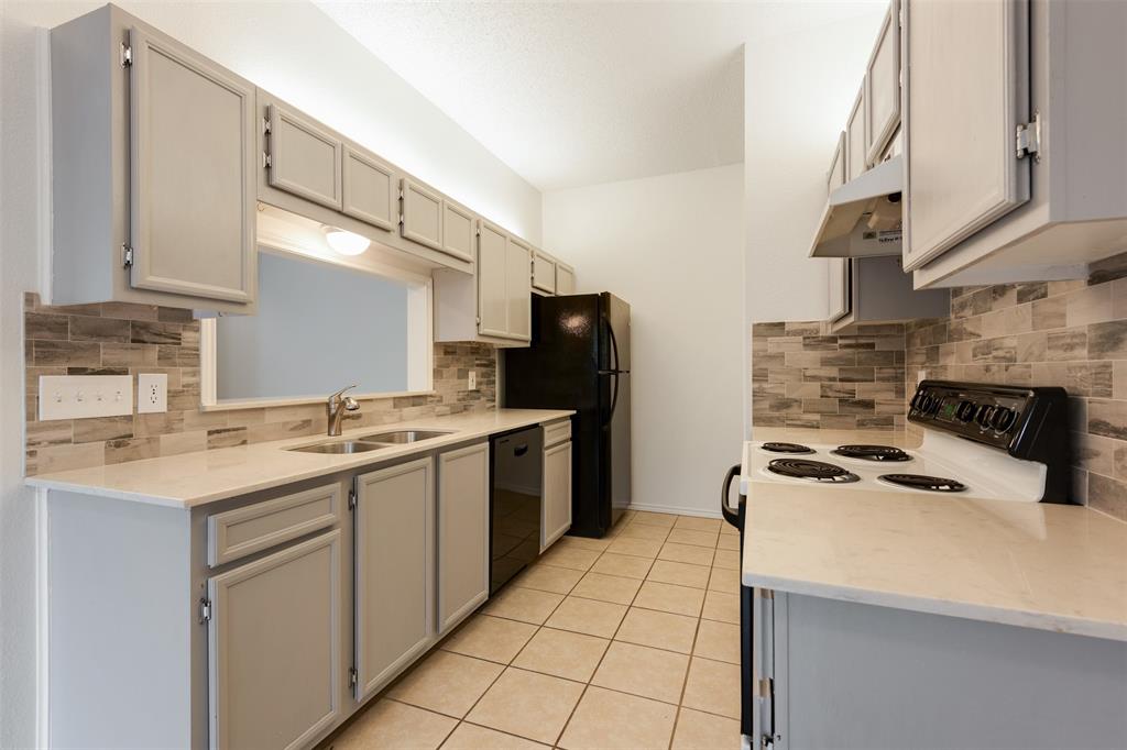 9100 Mountain Ridge Drive, Unit 105 Austin, TX 78759 - Photo 8 of 17 a kitchen with a sink a stove and cabinets