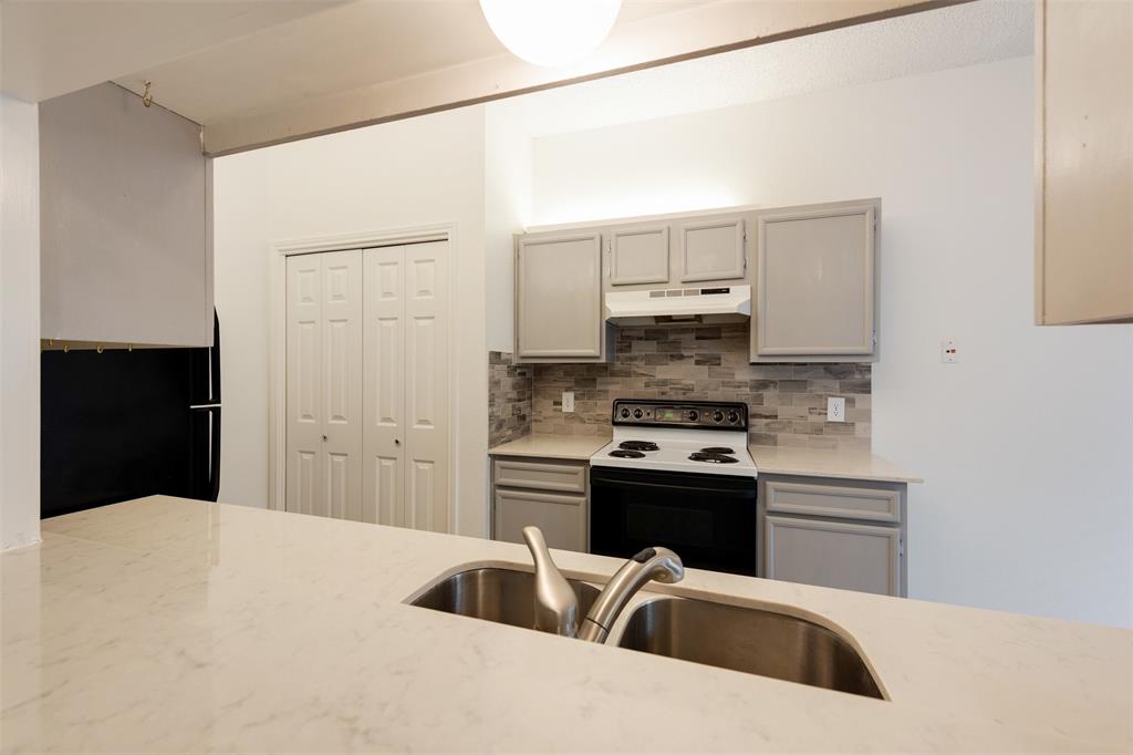 9100 Mountain Ridge Drive, Unit 105 Austin, TX 78759 - Photo 10 of 17 a kitchen with stainless steel appliances a stove a sink and a refrigerator