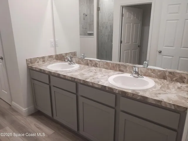 a sink vanity granite and a mirror