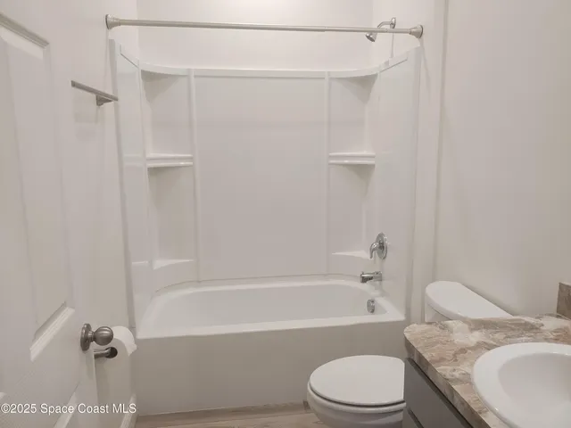 a bathroom with a granite countertop bathtub toilet and sink